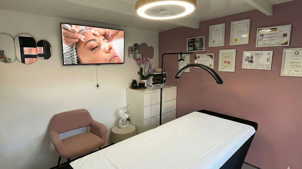 De behandelruimte met behandeltafel, roze stoel en de certificaten aan de wand
