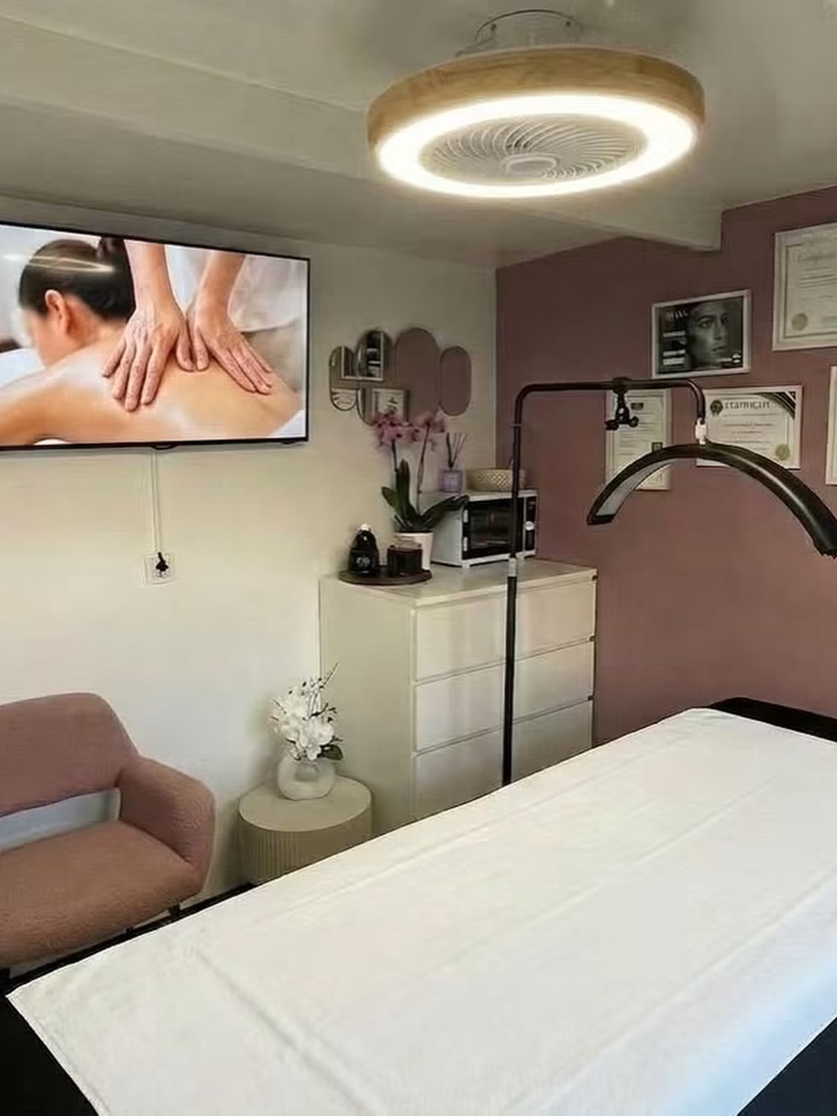 De behandelruimte met de massagetafel, roze stoel en orchidee